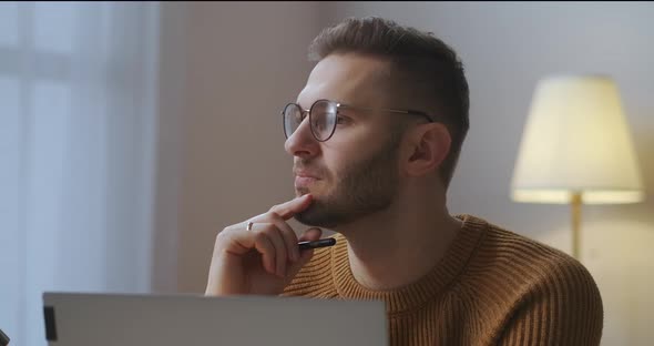 Man Is Working on Project at Home Freelance and Parttime Job Sitting in Front of Notebook in Room