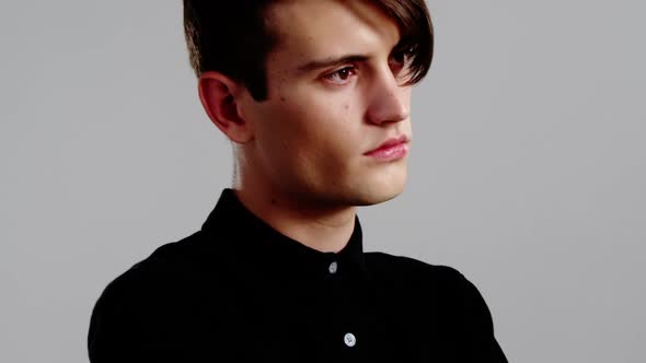 Androgynous man posing against grey background