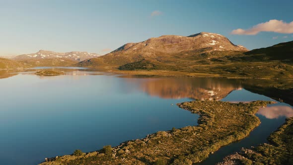 Mountain And Sky Reflections Over The Calm Water Of Vavatnet Lake During Golden Hour Sunrise In Hyda