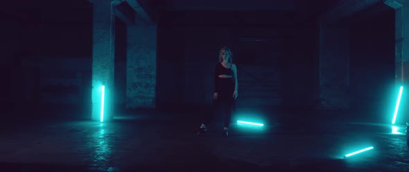 Female Dancer in a dark Parking Lot with Neon Lights