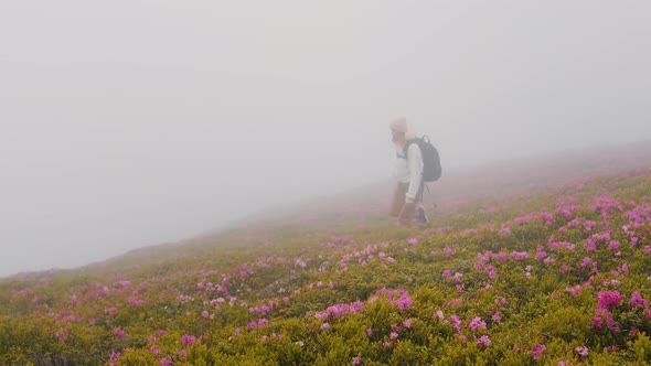 Difficult climbing female explorer in the misty mountains.