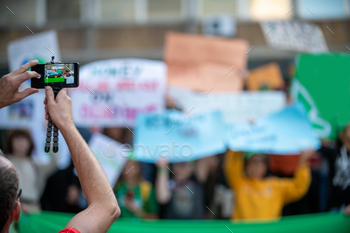  Holding Phone and Recording Protest.