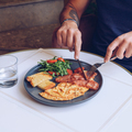 Close up of man's hands while he is taking his breakfast, omelette with bacon and salad - PhotoDune Item for Sale
