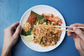 Hand holding chopsticks with Pad Thai food - PhotoDune Item for Sale