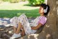 Black woman listening to music near tree - PhotoDune Item for Sale