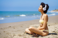 Relaxed ethnic lady listening to music and meditating on beach - PhotoDune Item for Sale