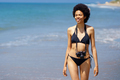 Joyful black woman with photo camera on wet coast - PhotoDune Item for Sale