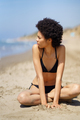 Black woman in bikini sitting near sea - PhotoDune Item for Sale