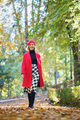 Cheerful woman in coat walking in park - PhotoDune Item for Sale