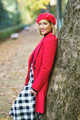 Charming woman standing near tree trunk in park - PhotoDune Item for Sale