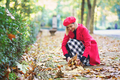 Smiling woman collecting leaves from ground in park - PhotoDune Item for Sale