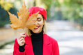 Smiling woman covering face with dry leaf - PhotoDune Item for Sale