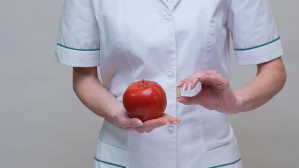 Nutritionist Doctor Healthy Lifestyle Concept - Holding Red Apple and Medicine or Vitamin Pill