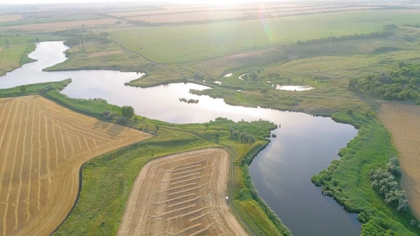 Scenic aerial view of winding river and agricultural fields