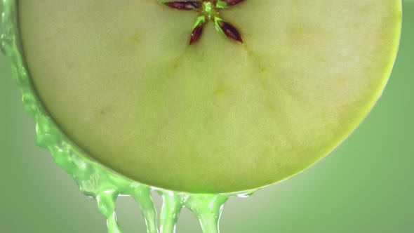 Flowing Green Apple Juice From Apple Slice  Macro Shot in Slow Motion