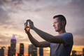 Man taking pictures via mobile phone of urban skyline - PhotoDune Item for Sale