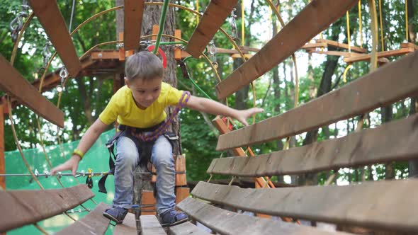 Close-up of a Small Boy Who Is Walking on an Obstacle Course. Rope Town