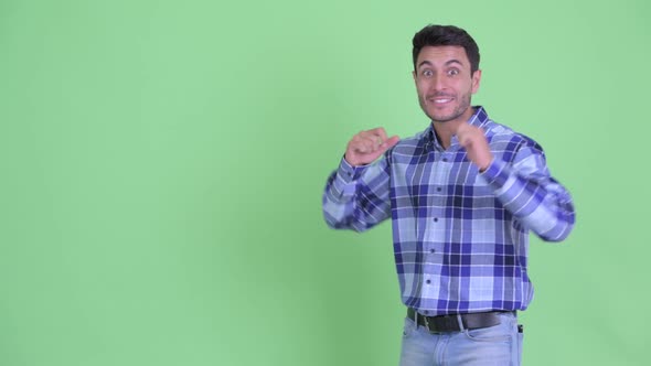 Happy Young Hispanic Man Presenting Something and Looking Excited