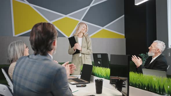 Group of Mature Colleagues Applauding to Lady Speaker Enjoying Her Presentation During Corporate