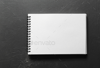 Blank sketchbook with white pages isolated on black background