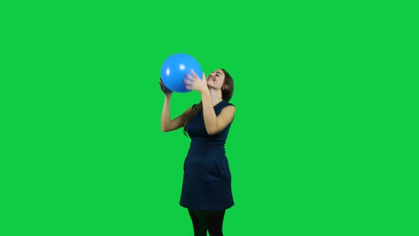 Girl playing with the balloon in front of a green screen