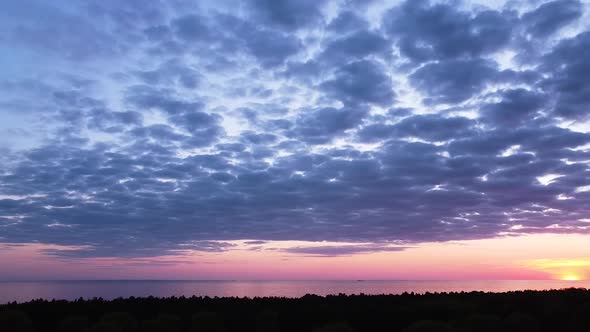 Beautiful aerial vibrant high contrast pink purple sunset with blue clouds over Baltic sea at Liepaj