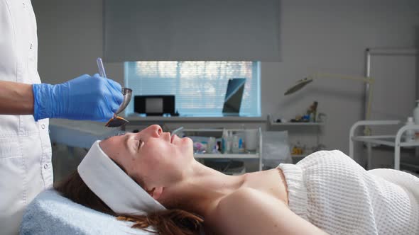 Cosmetologist Applying Mask with a Brush in Spa Center