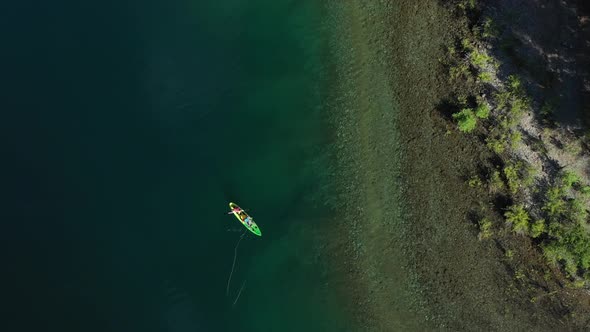 Aerial top down of two trained fishers catching trouts with dry fly technique near the shore in Lake