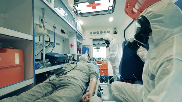 Ambulance with a Boy and Paramedics in Hazmat Suits