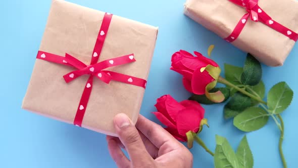 Top View of Man's Hand Holding a Gift Box on Table