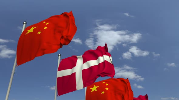 Waving Flags of Denmark and China on Sky Background