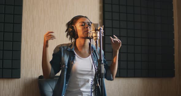 Young African American Lady Singing Song at Professional Sound Record Studio, Slow Motion