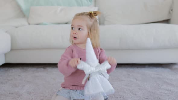 Adorable Little Girl Playing with White Doll