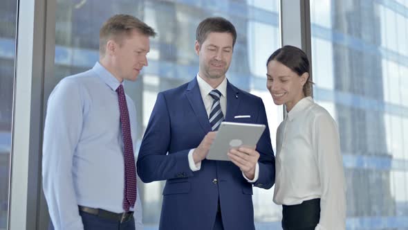 Successful Executive Business People Using Tablet and Celebrating in Boardroom