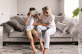 boy kid wearing virtual reality headset with his mother vr glasses in living room at home having fun - PhotoDune Item for Sale