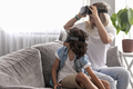 Mother and child wearing virtual reality headset vr glasses in living room at home having fun - PhotoDune Item for Sale