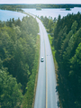 Aerial top view of country road through green woods and blue lakes in Finland - PhotoDune Item for Sale