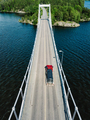 Aerial view of modern suspension bridge with car or truck over the blue lake water in Finland - PhotoDune Item for Sale