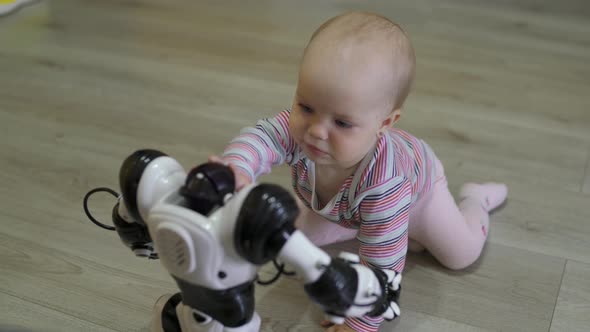 The Little Girl Carefully Looks at the Toy Robot and Dances with Him. Modern Robotic Technologies