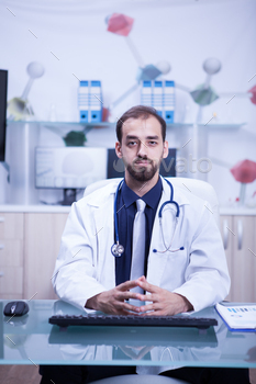 Young and inteligent doctor in his cabinet wearing a white coat and his stethoscope