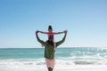 Cheerful african american father carrying daughter on shoulders at beach on sunny day, copy space - PhotoDune Item for Sale