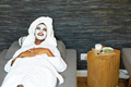 Cheerful young african american woman with face cream applied relaxing at home, copy space - PhotoDune Item for Sale
