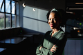 Portrait of smiling african american young businesswoman with arms crossed in office - PhotoDune Item for Sale