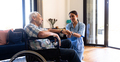 Biracial female health worker supporting caucasian senior man sitting on the wheelchair - PhotoDune Item for Sale