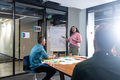 Biracial businesswoman explaining business plan to colleagues over flipchart in meeting - PhotoDune Item for Sale