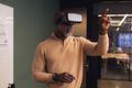 Mature african american businessman using virtual reality simulator pointing at creative office - PhotoDune Item for Sale