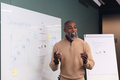 Confident mature african american businessman explaining strategy in board room at office - PhotoDune Item for Sale