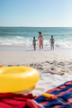 African american mother with children enjoying sea waves on shore at beach against clear blue sky - PhotoDune Item for Sale