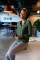 Portrait of cheerful african american young businesswoman with digital tablet sitting in office - PhotoDune Item for Sale