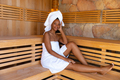 Portrait of young african american woman wrapped in towels sitting in sauna, copy space - PhotoDune Item for Sale